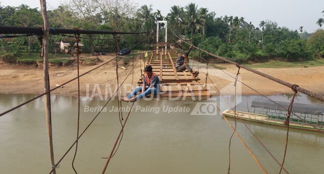 Warga sedang melakukan perbaikan jembatan gantung di Dusun Teluk Pandak, Bungo kemarin (8/10).