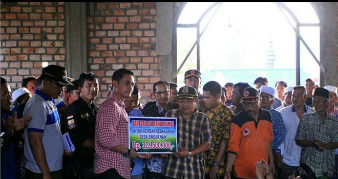 Zumi Zola (ketika menjabat gubernur Jambi), ketika menyerahkan bantuan Pemprov secara simbolis kepada Kepala Desa Simbur Naik, waktu itu.

