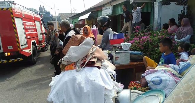 Terlihat Warga yang tengah mengungsikan Harta Benda yang Bisa Diselamatkan.