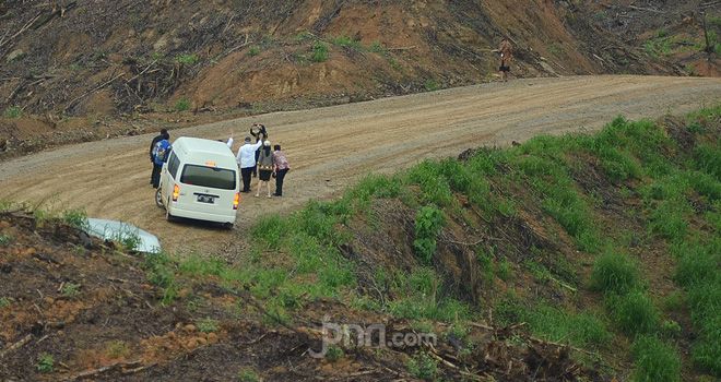 Mobil mini bus yang membawa rombongan menteri nyaris celaka di jalanan berlumpur dan menanjak di PPU, Kaltim, Selasa (16/12). 
