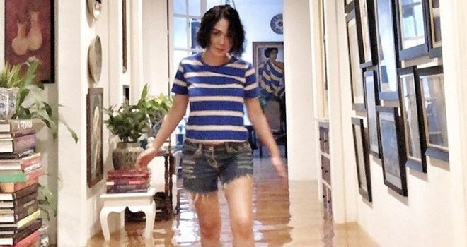 Yuni Shara di dalam rumahnya yang terkena banjir. 