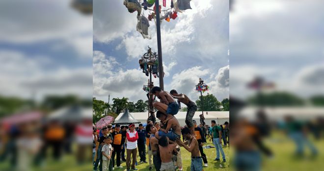 Gubernur Jambi menyaksikan panjat pinang kalangan remaja.