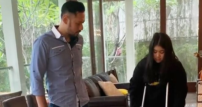 Agus Yudhoyono saat mengajarkan anaknya, Aira, berjalan pasca kecelakaan saat olahraga. 
