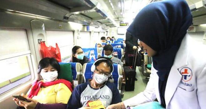 Petugas kesehatan membagikan masker dan pamflet kepada para penumpang di Stasiun Gambir, Jakarta, Jumat (31/1).