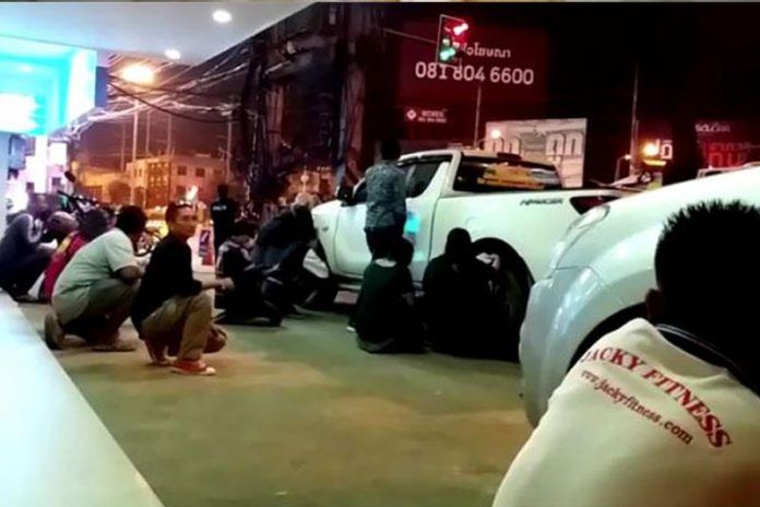 Sejumlah orang berlindung di balik kendaraan di dekat mal Terminal 21 saat penembakan massal di Nakhon Ratchasima, Thailand, Sabtu (8/2).