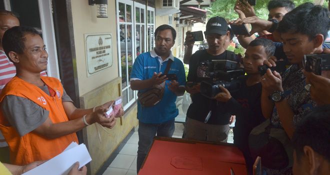 Tersangka Bodiansyah menunjukkan barang bukti berupa Pil Ekstasi yang diselundupkannya ke Kota Jambi dari Tanjab Barat.