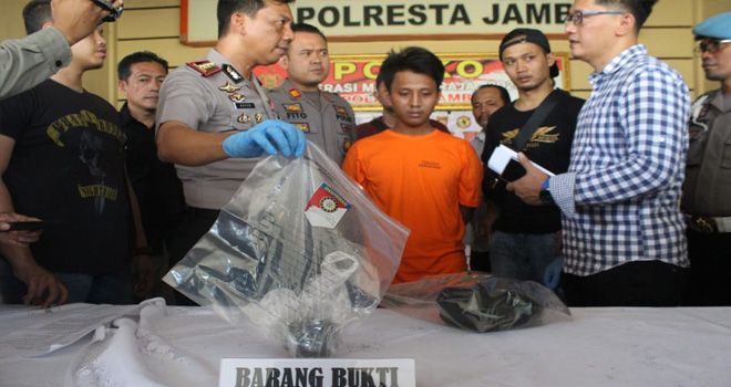 Tersangka bersama barang bukti pembunuhan yang tunjukkan oleh petugas saat melakukan pemeriksaan di Mapolresta Jambi beberapa waktu lalu. Hanya saja barag bukti berupa pisau yang digunakan untuk membunuh belum ditemukan