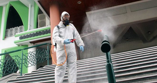 Petugas menyemprot Masjid Baiturahman, Kompleks Parlemen, Jakarta dengan cairan desinfektan sebagai upaya menekan penularan virus corona. 