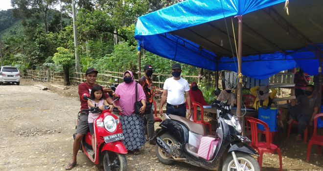 Terlihat warga diberikan masker di posko penjagaan di pintu masuk Desa Nalo Gedang.

