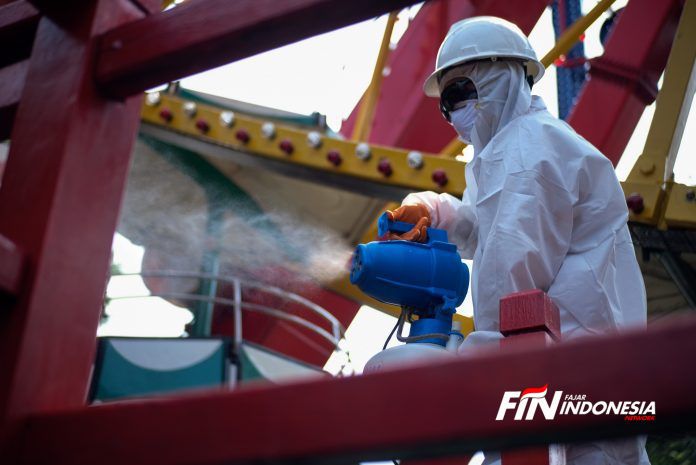 Petugas mengenakan pakaian pelindung penyemprotan disinfektan di area Dufan, Ancol, Jakarta, (14/3).Pembersihan sejumlah wahana di Dufan dengan menggunakan cairan disinfektan guna mengantisipasi penyebaran virus corona (Covid-19). 