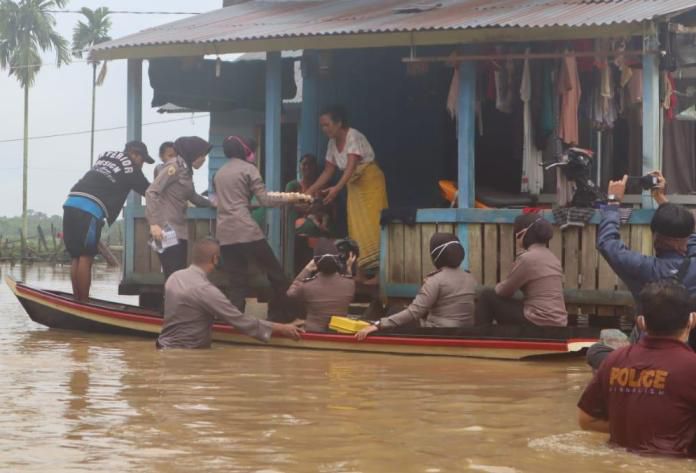 Personel Polres Muaro Jambi memberikan bantuan sembako untuk korban banjir di Pematang Jering, Muaro Jambi.
