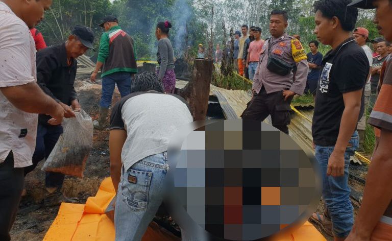 Warga bersama petugas mengevakusi jasad korban kebakaran untuk langsung dimakamkan.