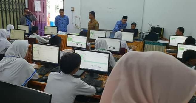 Kabid Dikdas Dinas Pendidikan Kota Sungai Penuh, Roli Darsa, saat memantau KBM di Sungai Penuh.