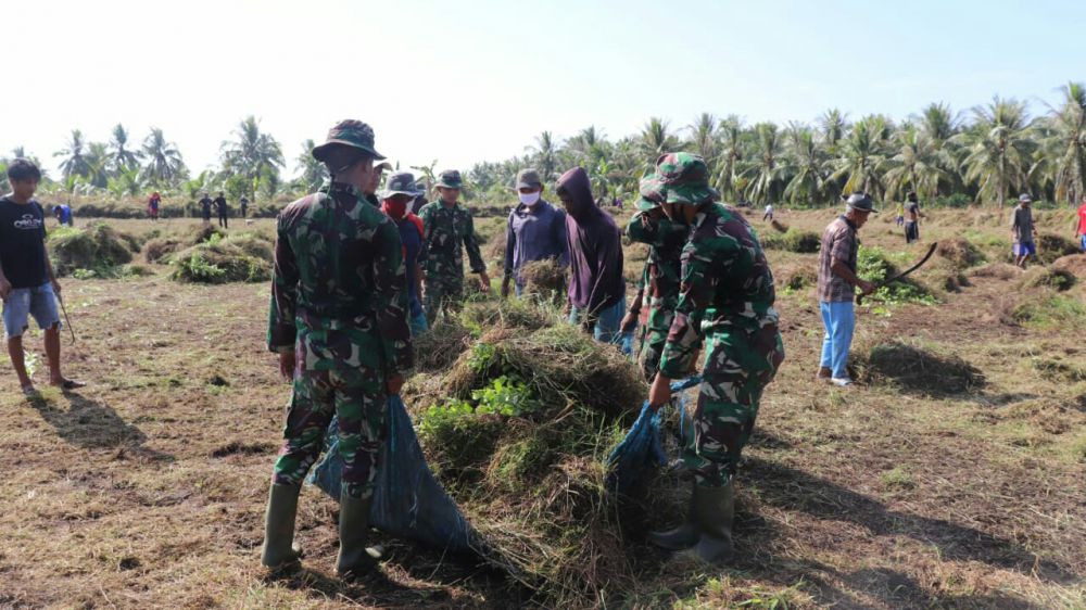 Personel Satgas TMMD Kodim Tanjab Bersama Warga Bersihkan Lapangan Sepakbola