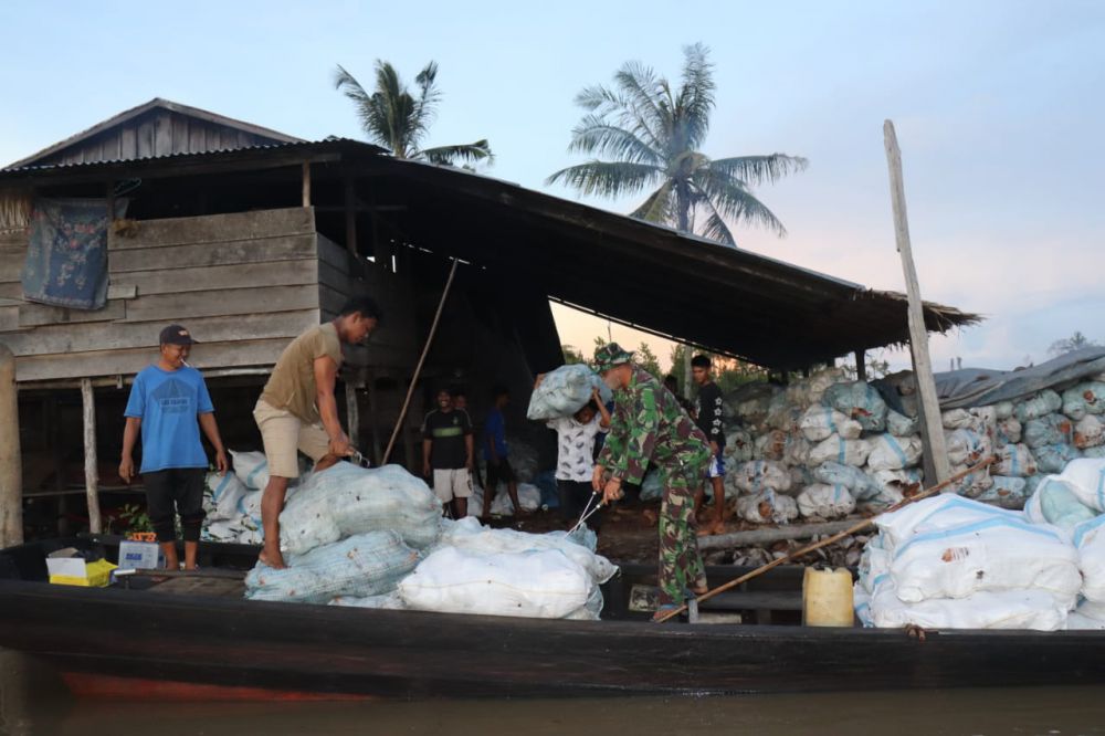 Kepedulian Anggota Satgas TMMD Bantu Warga Muat Kelapa ke Pompong