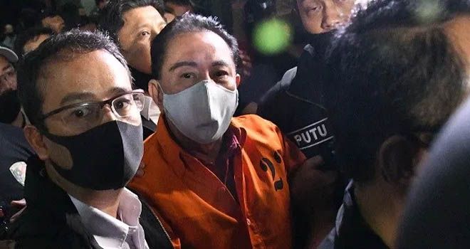Anggota Bareskrim Mabes Polri mengawal tersangka tersangka korupsi, Djoko Tjandra selama kedatangannya di bandara Jakarta, Kamis (30/7) malam, setelah ditangkap di Malaysia dalam pelariannya yang menyebabkan beberapa jenderal polisi diberhentikan karena keterlibatan mereka. (FOTO:DASRIL ROSZANDI/AFP)