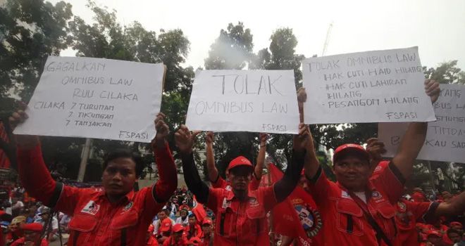 Massa yang tergabung dari Gerakan Buruh Jakarta menggelar aksi unjuk rasa menyerukan penolakan omnibus law di depan Gedung DPRD DKI Jakarta, Jakarta Pusat, (12/3).
