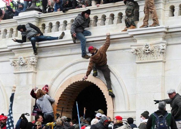 Pendukung Presiden Donald Trump memanjat dinding Gedung Capitol saat protes terhadap pengesahan hasil pemilihan presiden Amerika Serikat oleh Kongres di Washington, Rabu (6/1). (REUTERS/STEPHANIE KEITH)
