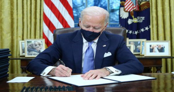 Presiden Amerika Serikat Joe Biden menandatangani 15 kebijakan baru pada hari pertamanya berkantor di Ruang Oval Gedung Putih, Selasa (20/1). Foto: Reuters