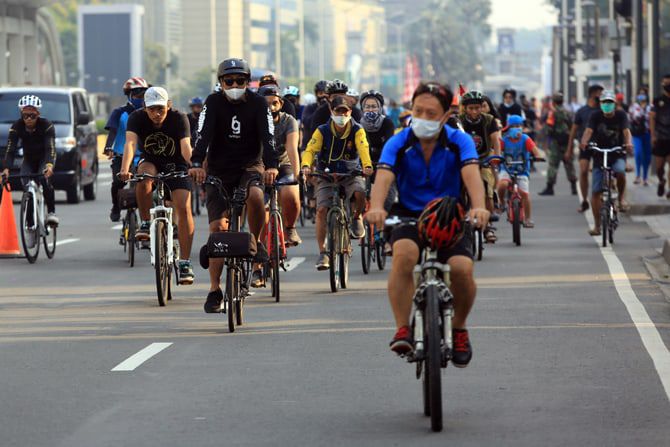 Ilustrasi warga berolahraga dengan bersepeda 