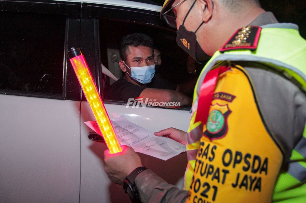 Petugas kepolisian memeriksa dokumen pengendara yang melintas dari arah Jakarta ingin menuju keluar Jakarta di Pintu Tol keluar Cikarang Barat, Kamis (6/05) dini hari. Pemeriksaan tersebut terkait larangan mudik lebaran 2021 yang dimulai dari tanggal 6 hingga 17 Mei sebagai upaya mengantisipasi risiko peningkatan kasus penularan COVID-19 jelang perayaan Hari Raya Idul Fitri 1442 H. 