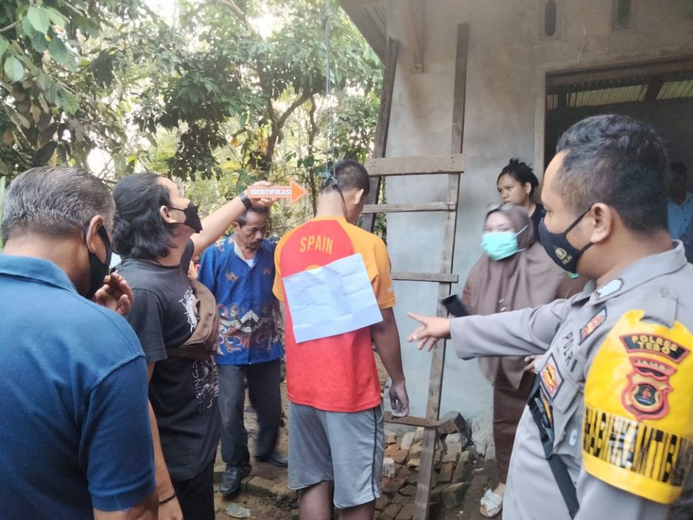 Petugas dibantu warga saat melakukan penurunan jenazah Julius Anggara Purba yang ditemukan tewas gantung diri.
