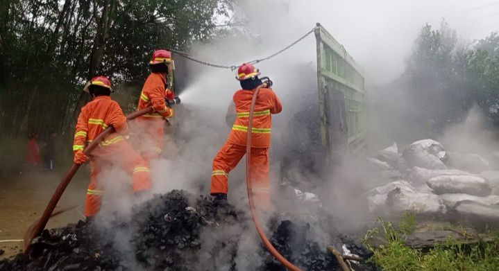Petugas Damkar saat berusaha memadamkan api yang hampir menghanguskan satu unit truk pengangkut arang.