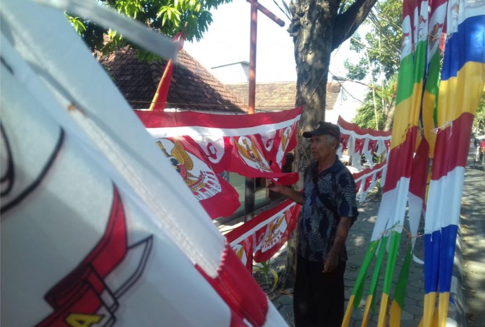 Para penjual yang menunggu pembeli bendera merah putih di pinggir jalan. 