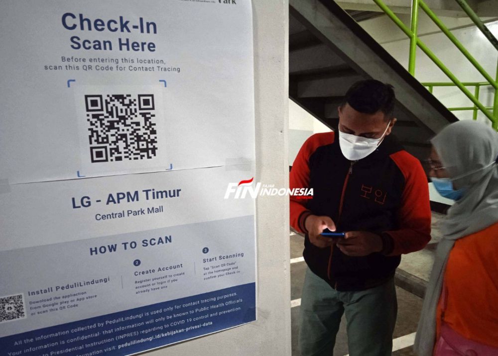 Pengunjung saat melakukan scan QR code untuk mengakses kartu vaksin sebelum memasukin pusat perbelanjaan Mall Central Park, Jakarta, Kamis (19/08). 
