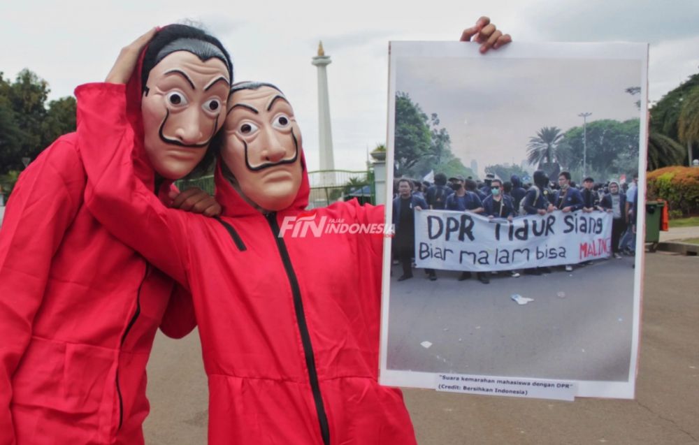 Sejumlah masyarakat yang tergabung dalam #bersihkanindonesia menggelar aksi teatrikal dengan memakai topeng dan membawa bingkai foto di kawasan Monas, Jakarta, Selasa (15/12). 