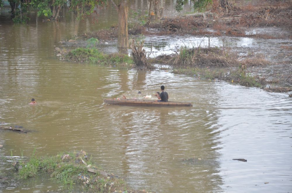 Luapan sungai di bawah Jembatan Makalam dimanfaatkan anak-anak untuk bermain air.