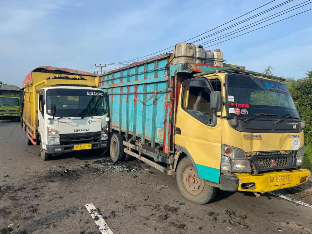 Istirahat di depan ban mobil, seorang sopir truk batu bara tewas terlindas truknya sendiri, usai dihantam truk lain dari belakang.