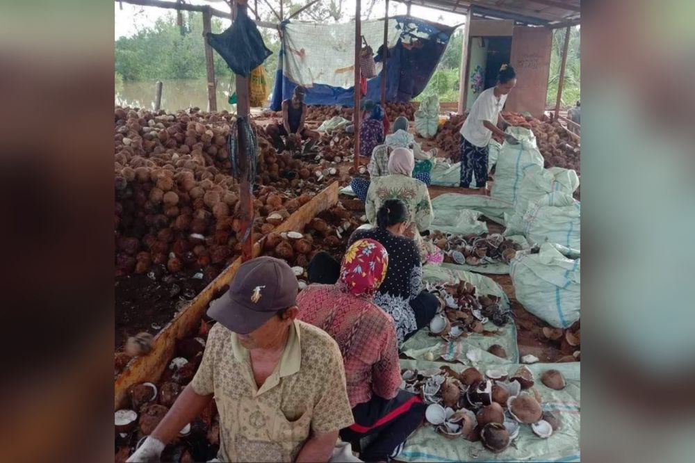 Aktifitas masyarakat saat mengambil upah kocek kelapa di gudang Desa Majelis Hidayah, Kecamatan Kuala Jambi.