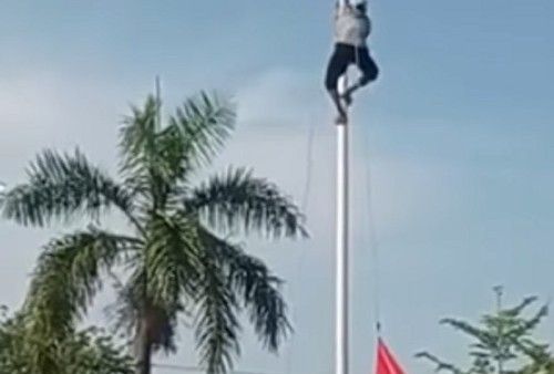 Seorang petani panjat tiang bendera.