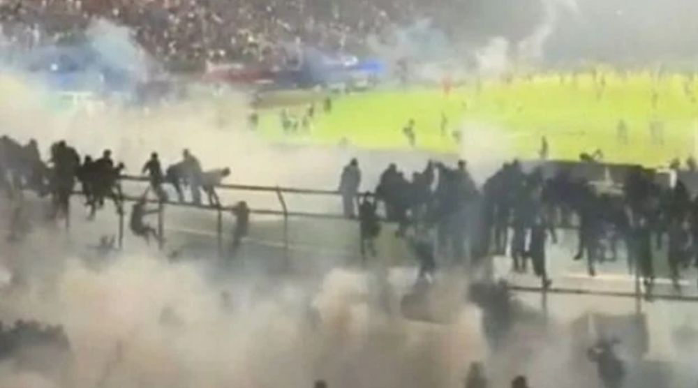 Polisi menembakkan gas air mata ke arah tribun Stadion Kanjuruhan saat pengamanan kerusuhan laga Arema FC vs Persebaya Surabaya, Sabtu (1/10) malam. 