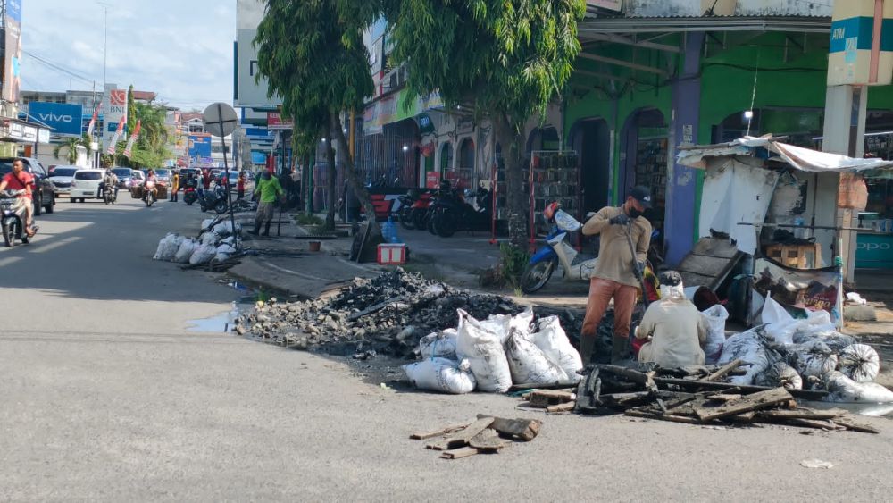 PEMBERSIHAN: Petugas dari dinas PUPR Bungo melakukukan pembersihan saluran drainase di Pasar Muara Bungo