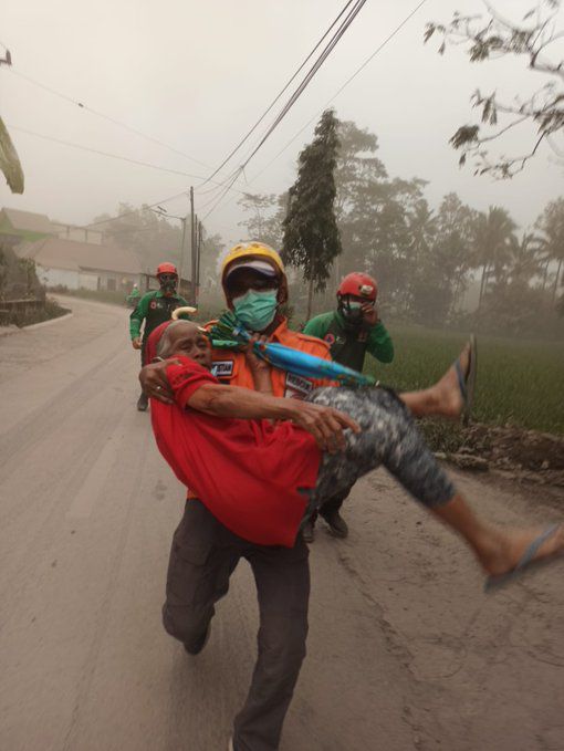 Petugas BPBD Lumajang mengevakuasi seorang nenek yang masih di rumah saat terjai erupsi Gunung Semeru.
