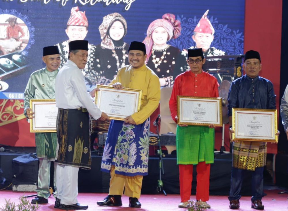 PENGHARGAAN : Bupati Bungo H. Mashuri menerima sertifikat Warisan Budaya Tak Benda pada malam puncak HUT Provinsi Jambi ke-66