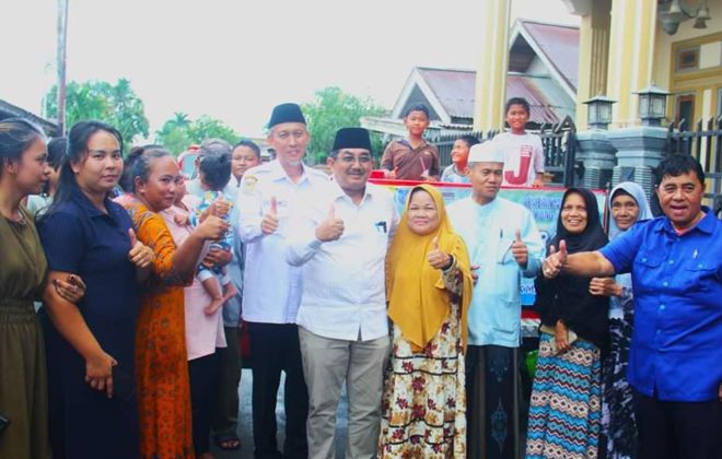 Usai berbagii air bersih, Bupati Tanjabbar didampingi Sekda dan direktur PDAM Tirta Pengabuan foto bersama dengan warga RT 17 dan RT 16 Kelurahan Tungkal Harapan.