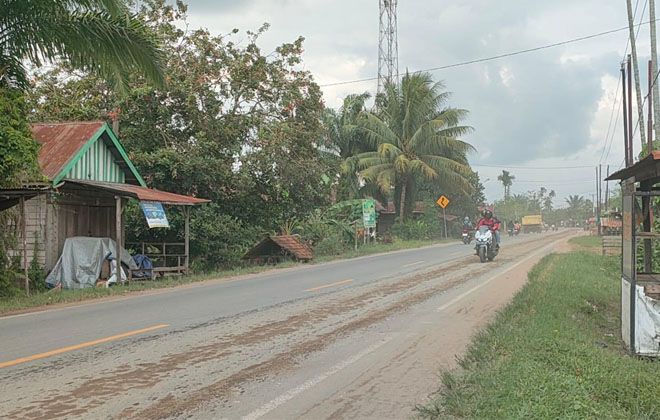 Kondisi jalan Lintas Timur Jambi yang dikeluhkan warga akibat banyaknya pasir yang berterbangan.