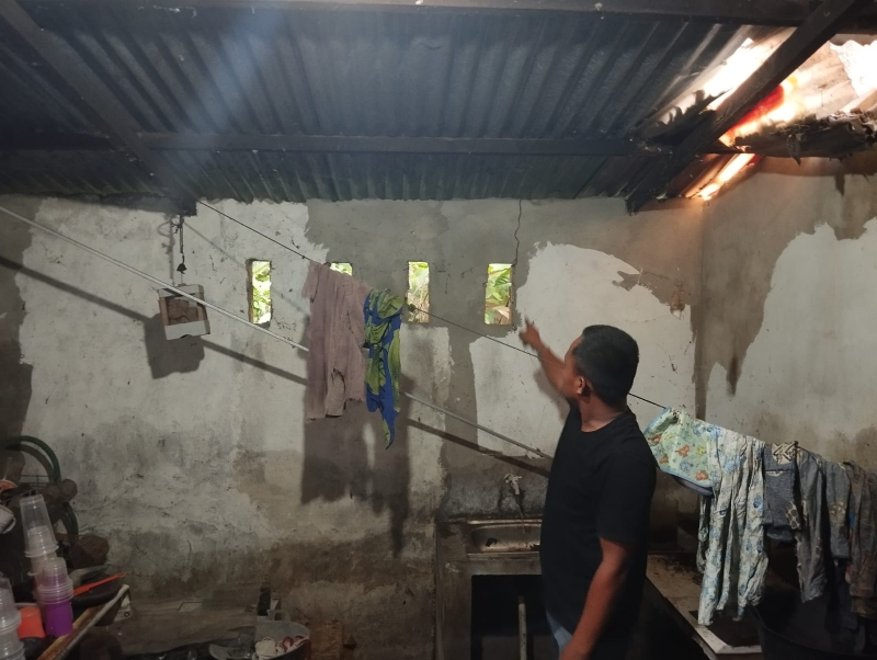 Warga melihat rumah mereka yang retak akibat pembangunan gudang PT. Oscarmas. 