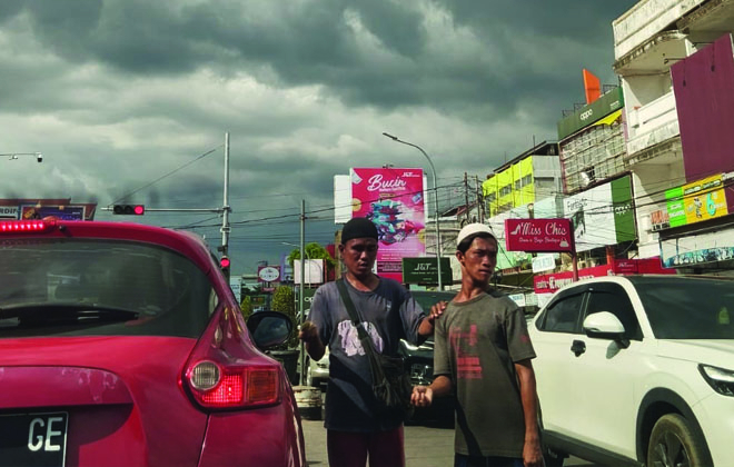 Terlihat kawanan pengemis duduk di salah satu persimpangan Kota Jambi. Mereka semakin ramai mendekati lebaran.