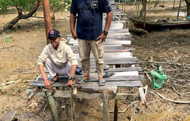 Tampak pengendara sepeda motor yang terjatuh akibat jalan jerambah kayu ambruk ke bawah.