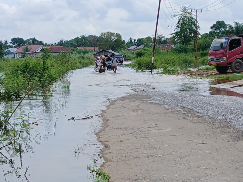 BANJIR: Air mulai menggenangi jalan utama depan Kantor Lurah Legok (25/4) kemarin.
