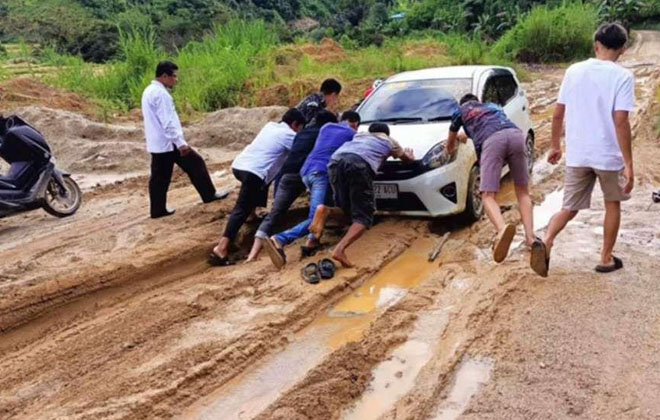 Imbas jalan rusak, mobil warga yang melintasi jalan protokol menuju pusat Kecamatan Gunung Kerinci, terpaksa didorong.