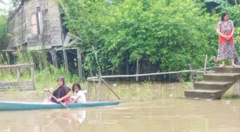 Banjir mulai merendam pekarangan rumah warga. 