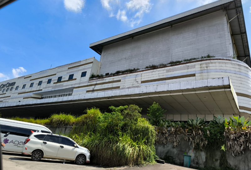 Kondisi Mall JCC yang semak dan kini halamannya hanya jadi tempat parkir mobil travel. Mall yang dibangun di atas tanah milik Pemkot Jambi ini seharusnya mulai beroperasi sejak 2020 namun tak ada kabar beritanya sampai hari ini
